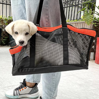 chiot dans son sac de transport pour chien Filet visibilite orange porté par sa maitresse