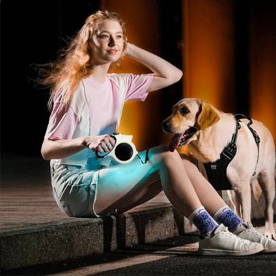 femme assise sur tottoir avec son chien en laisse de chien lumineuse