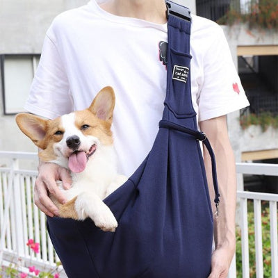 Femme portant son chien heureux dans sac transport chien Nomade bleu