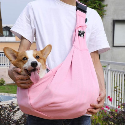 Femme portant son petit chien dans sac transport chien Nomade rose 