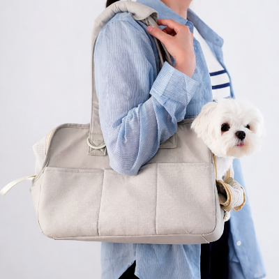 femme portant son petit chien heureux dans son chien sac de transport Premium Canin gris