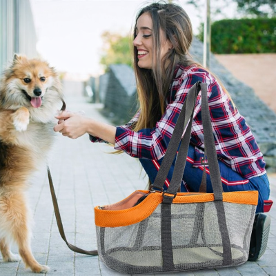 femme prenant son chien pour le mettre dans son sac de transport pour chien Filet visibilite orange