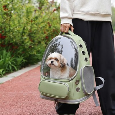 Homme tenant son chien dans sac a dos chien Canipack kaki à la main