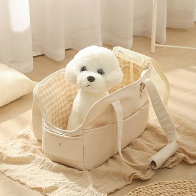 Petit chien blanc posé dans chien sac de transport Premium Canin écru