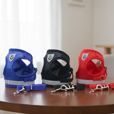 Trois harnais chien Confort Max Bleu, Noir, Rouge sur une table 